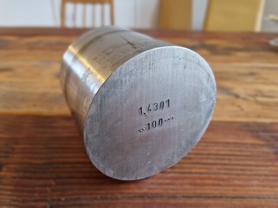 Edelstahl-Rundstange auf Holztisch (Rückseite gesägt)