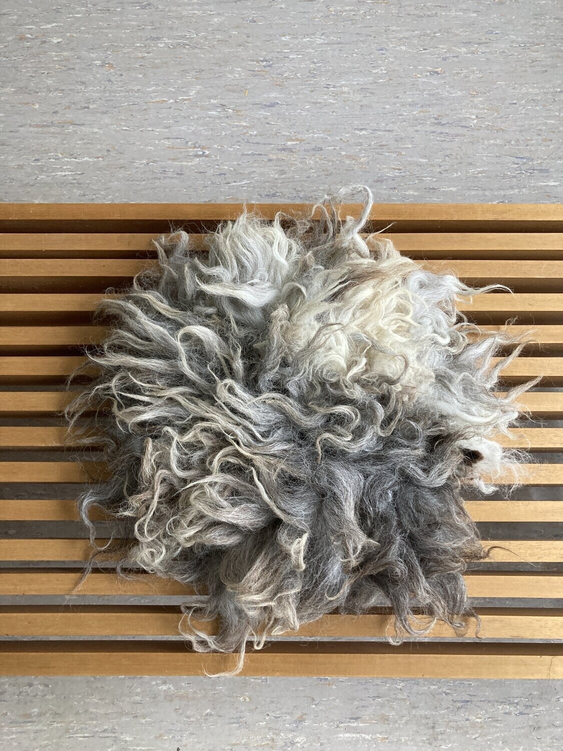 Sitzkissen "Rakete" #8 mit langen hellgrauen Haaren und dunkelgrauen Flecken