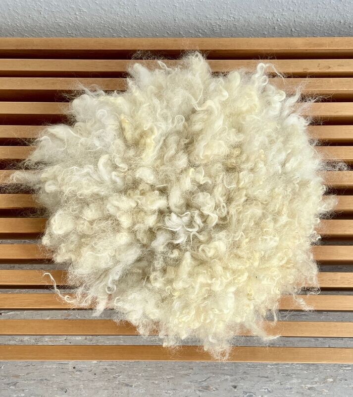 Sitzkissen "Löckchen"  mit langen hellen Haaren in weiss und beige vom Walliser Schwarznasenschaf