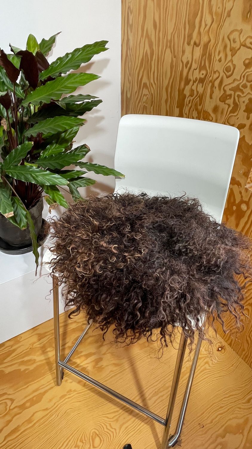 Sitzkissen satt braun vom ungarischen Zackelschaf, schön glänzend und lockig Sitzkissen satt braun vom ungarischen Zackelschaf, schön glänzend und lockig