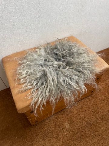 Sitzkissen vom ungarischen Zackelschaf mit langen hellgrauen Haaren in verschiedenen Tönen