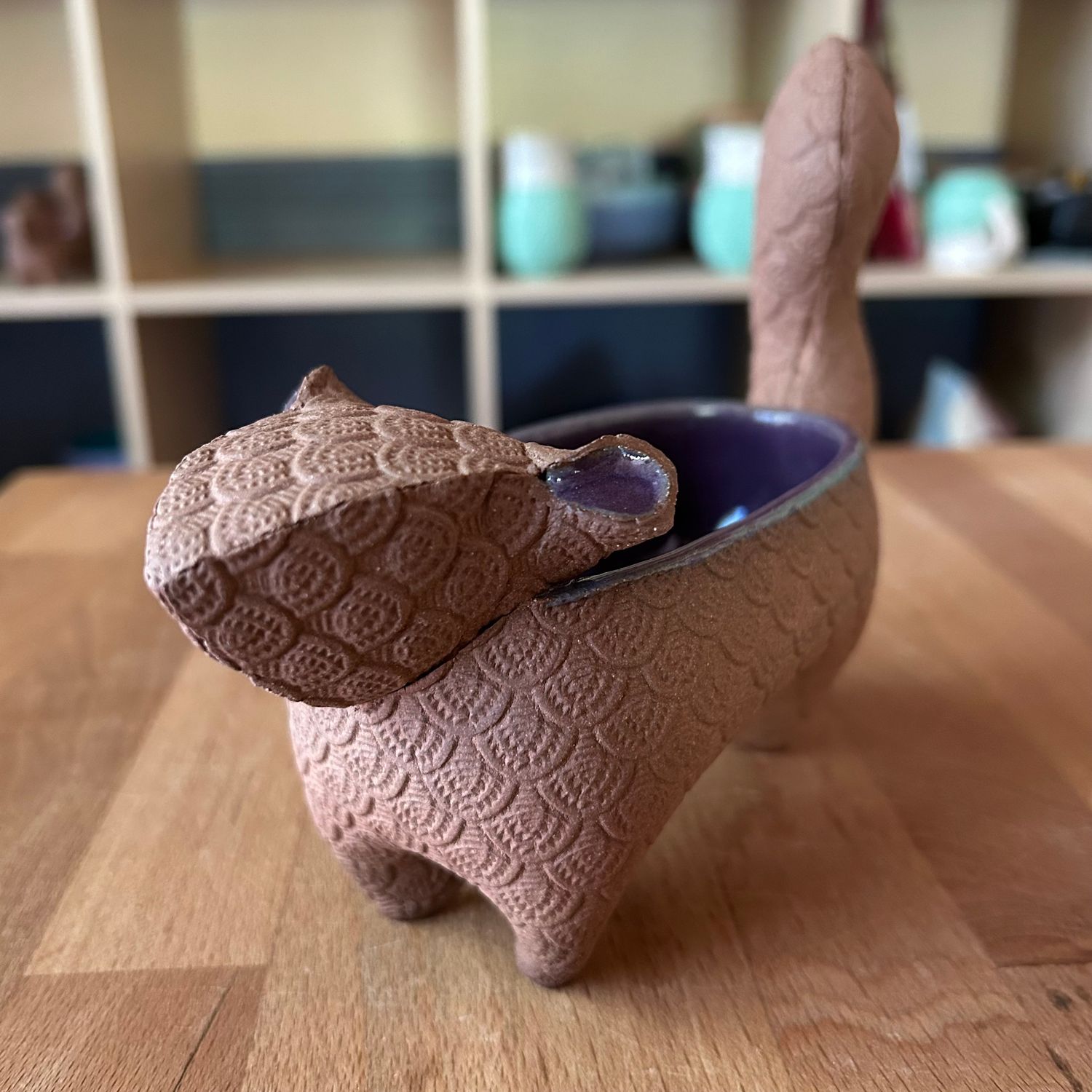 Small Squirrel in purple and bare brown clay