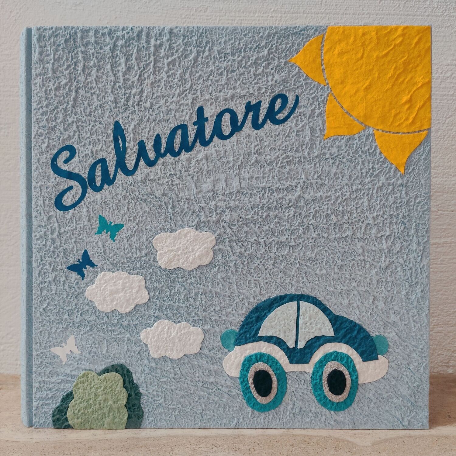 Album fotografico celeste con automobilina, sole e nome