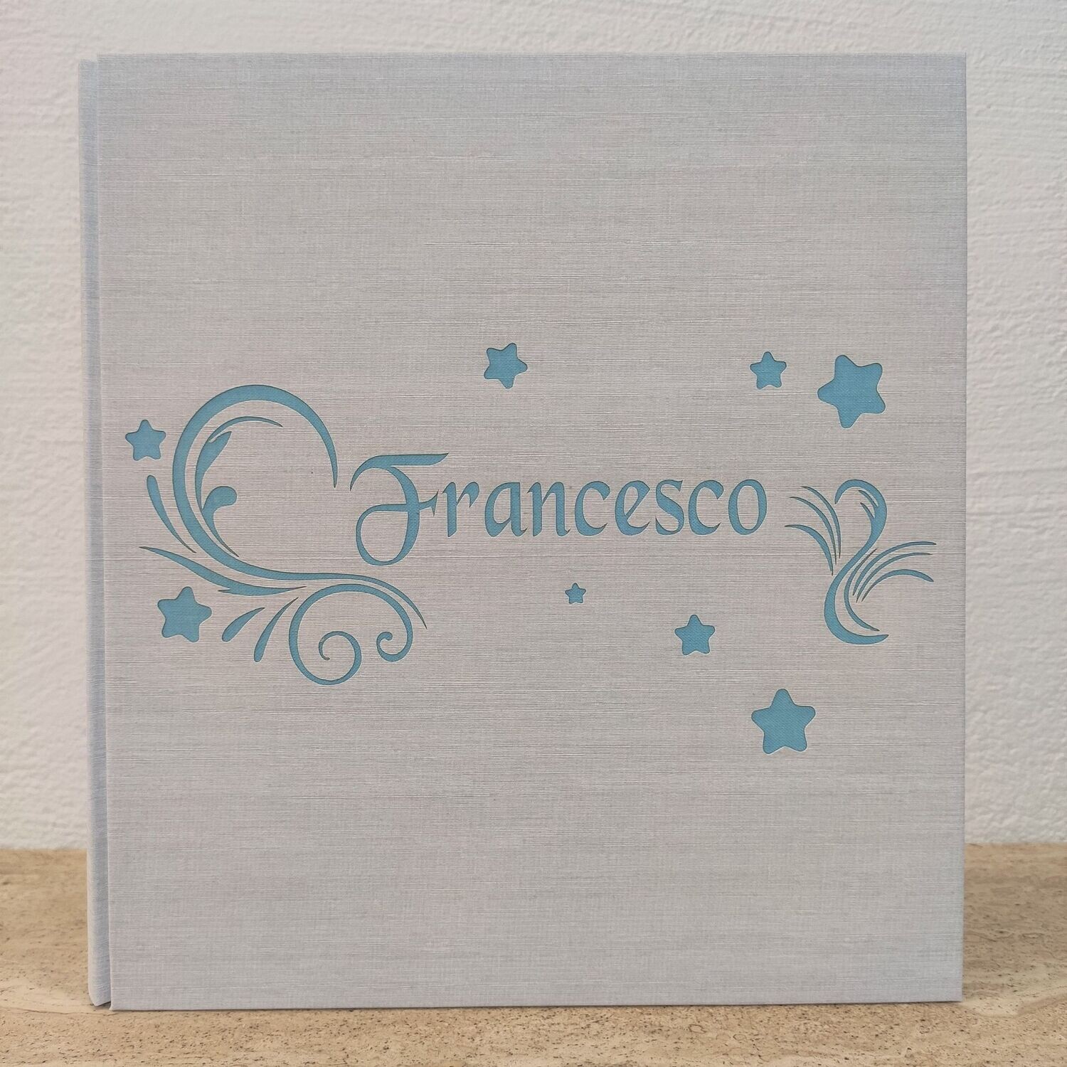 Album fotografico con nome, decori e stelle Album fotografico con stelle e nome inciso
Le copertine dei nostri album sono in legno rivestite in questo caso in tela di lino.
Il nome in copertina e i colori sono personalizzabili.