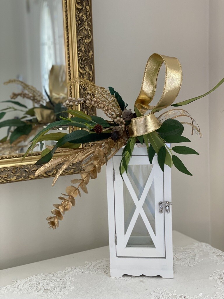 Botanical gold luxe lantern topper on slim white wood criss-cross silver-top lantern.