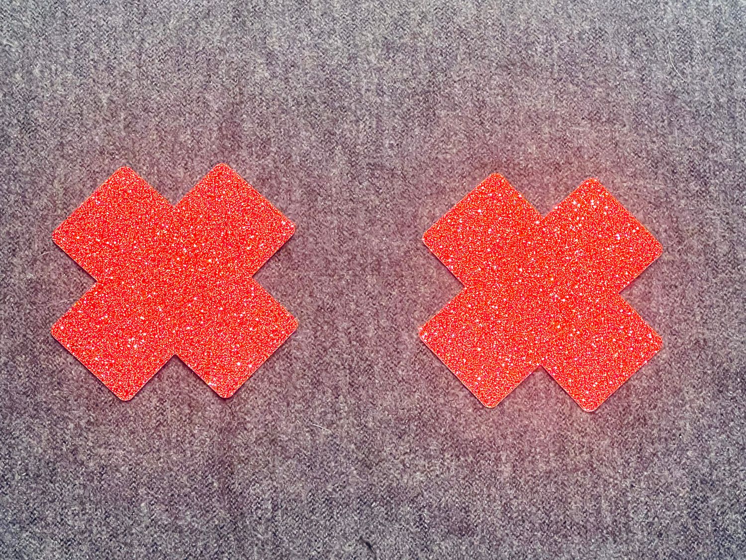 2 rote Glitzerkreuz-Pasties. Selbstklebend. 1x verwendbar.