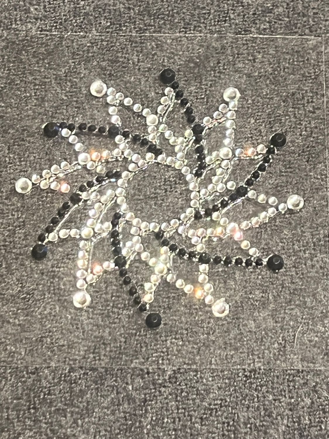 Brustverzierung schwarz/transparent. Durchmesser: 7 cm.