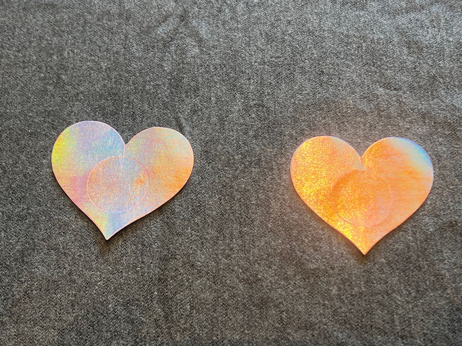 2 pinke Herz-Pasties mit schillernder, glatter Oberfläche.