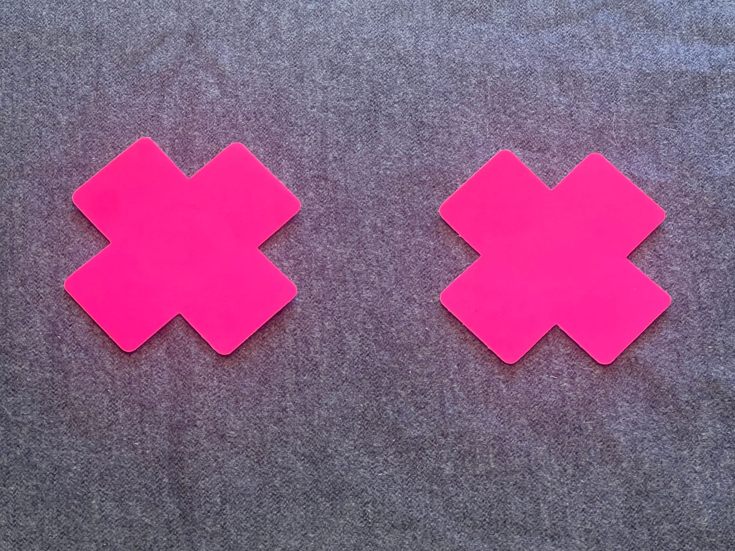 2 leucht-pinke Kreuz-Pasties,. Selbstklebend. 1x verwendbar.