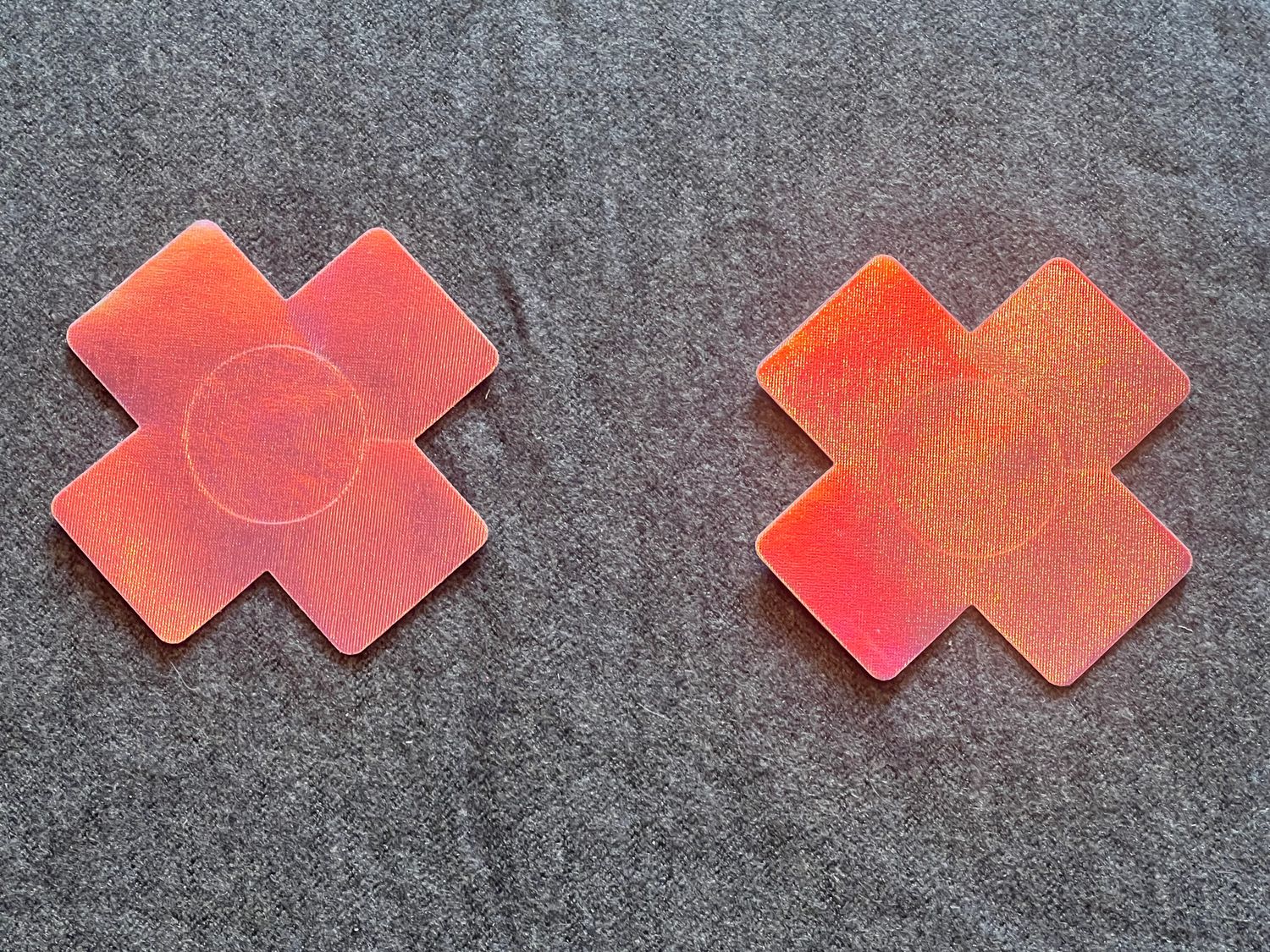 2 pink glänzende Kreuz-Pasties,. Selbstklebend. 1x verwendbar.