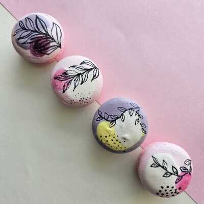 Macarons in pastel colours with line art leaves hand painted on it