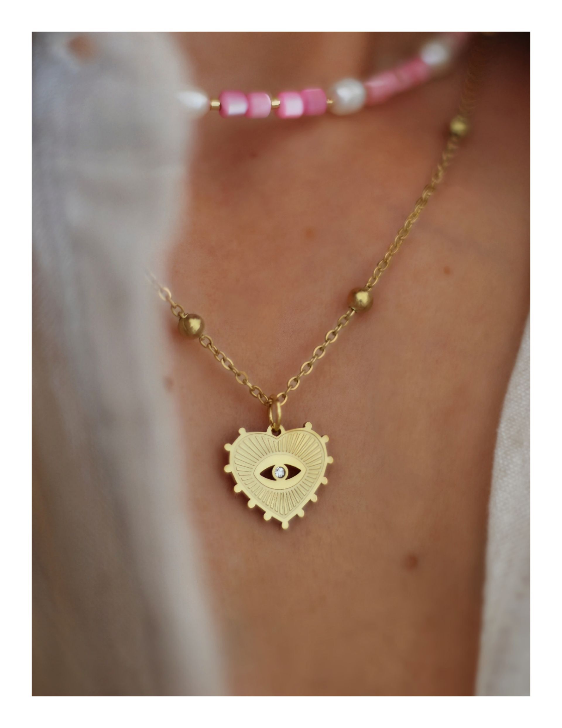 Goldene Halskette mit Herzanhänger und sehendem Auge im Boho-Chic. Perfekter Talisman für Layering-Looks.