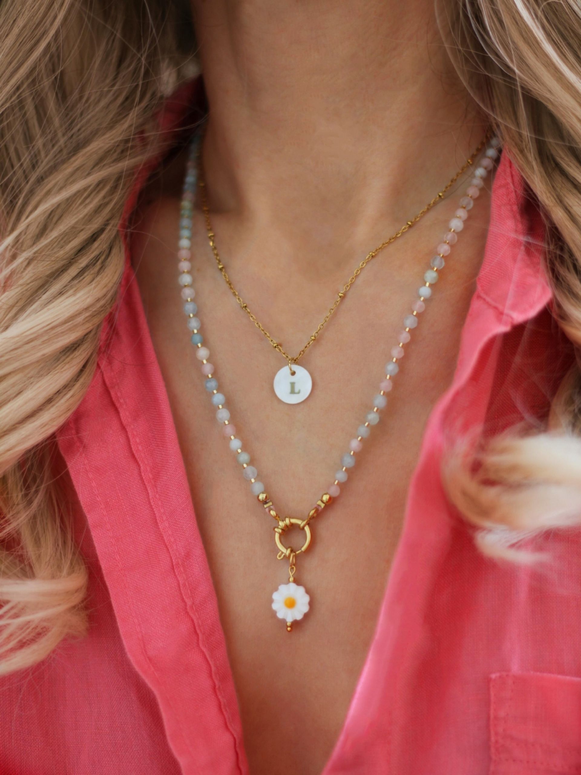 Zarte goldene Edelstahl Halskette mit kleinen Perlen, an der ein runder Perlmutt-Anhänger mit einem Buchstaben hängt.