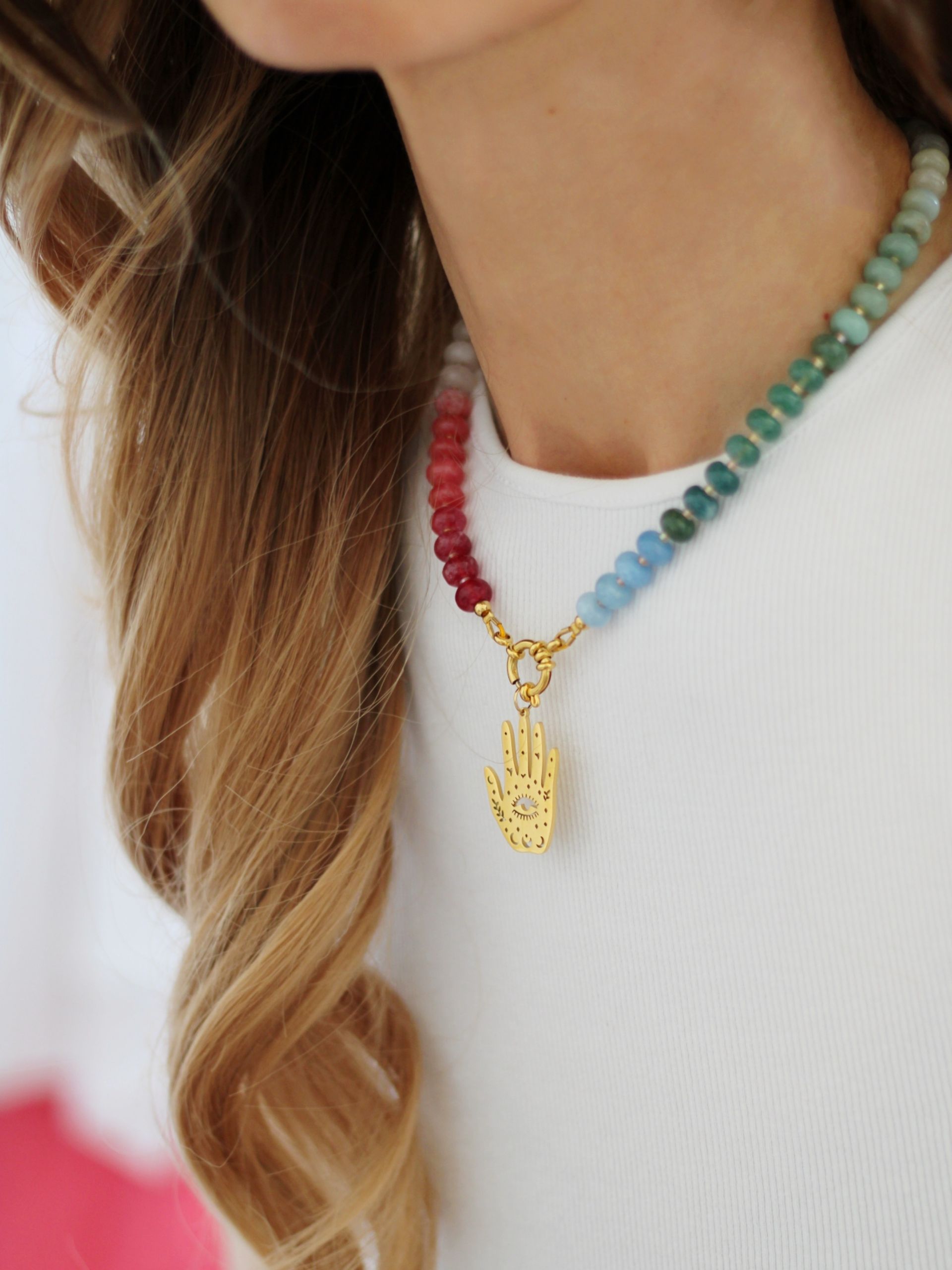 Ein goldener Anhänger in Form einer Hand aus Edelstahl. Anhänger für Ohrringe und Halsketten. Bunter Schmuck