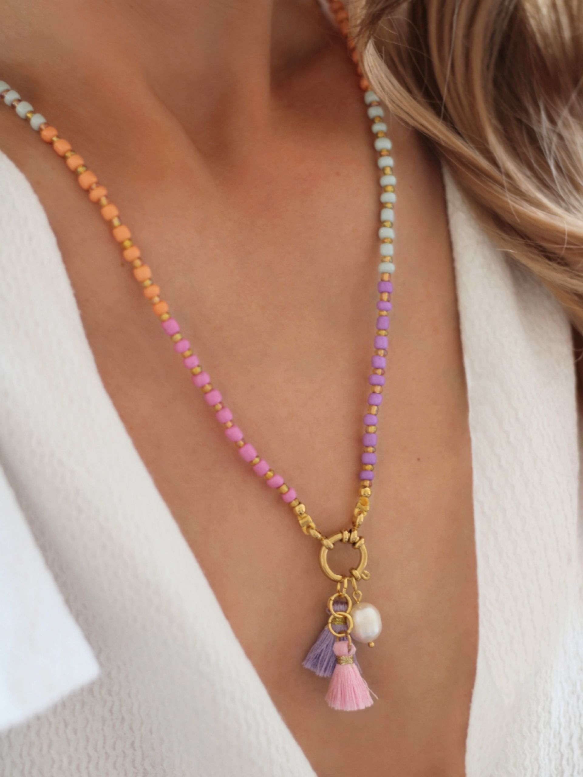 Lange bunte Perlenkette im Ibiza-Boho-Stil aus den Pastellfarben Violett, Orange, Pistazie und Rosa mit goldenen Akzenten
