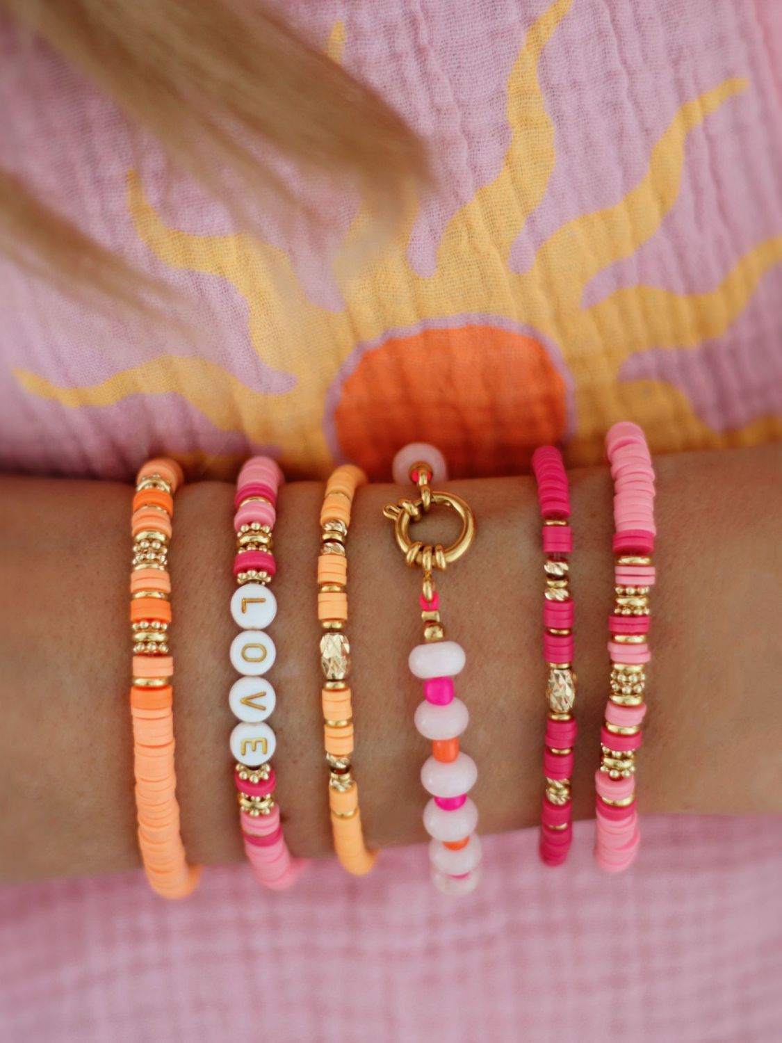 Tragebild von verschieden, handgemachten Armbändern in pink und Orange von Bunter Schmuck - IT-Pieces für deinen Sommer