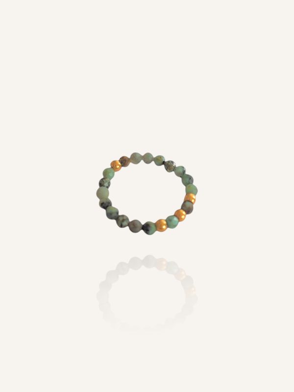 Elastischer Ring aus türkis-grünen Edelsteinen und goldenen Edelstahlperlen. Hübsches Accessoire und tolles kleines Geschenk