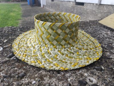 Natural harakeke pōtae with yellow zigzag pattern