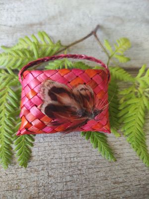 Orange/pink harakeke kete brooch with feathers