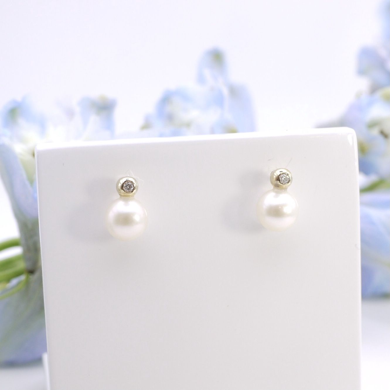 Pearl studs with round-cut diamonds