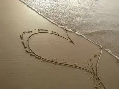 Coeur dessiné sur une plage au bord de l&#39;eau. Découvrez l&#39;évolution de votre vie amoureuse, de votre couple, grâce à la voyance par mail amour
