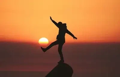 Individu à la recherche de son équilibre face au soleil couchant, guidance mail pour vous aider à harmoniser les différents aspects de votre vie
