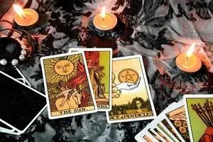 3 bougies allumées et quelques cartes de tarot divinatoire pour illustrer ce qu&#39;est un véritable professionnel de la voyance