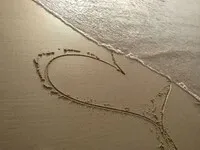 Coeur dessiné sur une plage au bord de l&#39;eau. Illustration de la voyance par mail amour :  l&#39;évolution de votre couple