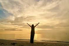 Guidance par mail – Vos énergies de l’été femme levant les bras au soleil couchant en illustration de la prestation guidance par mail vos énergies de l'été