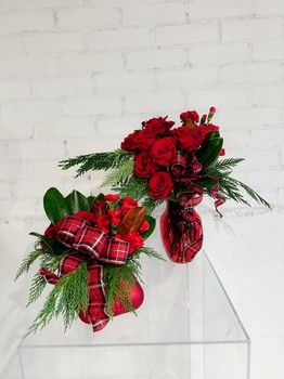 Classical Holiday Christmas flower arrangements with red roses, evergreen greenery and festive plaid ribbon