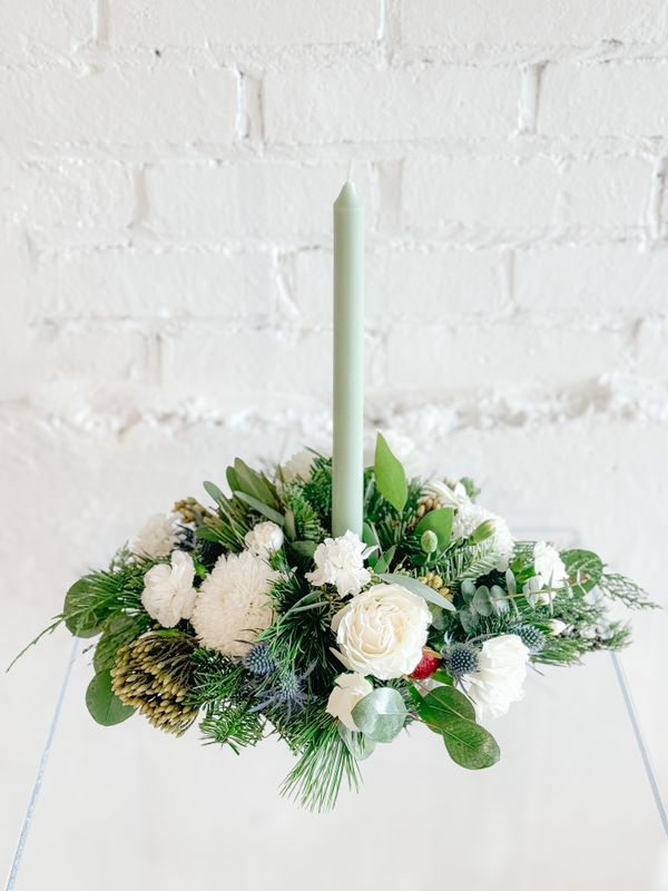 White Christmas floral table arrangement with fresh evergreens, roses and candles