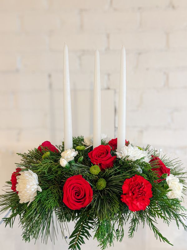 Large red and white Christmas centrepiece with three white candles, red roses and fresh greenery