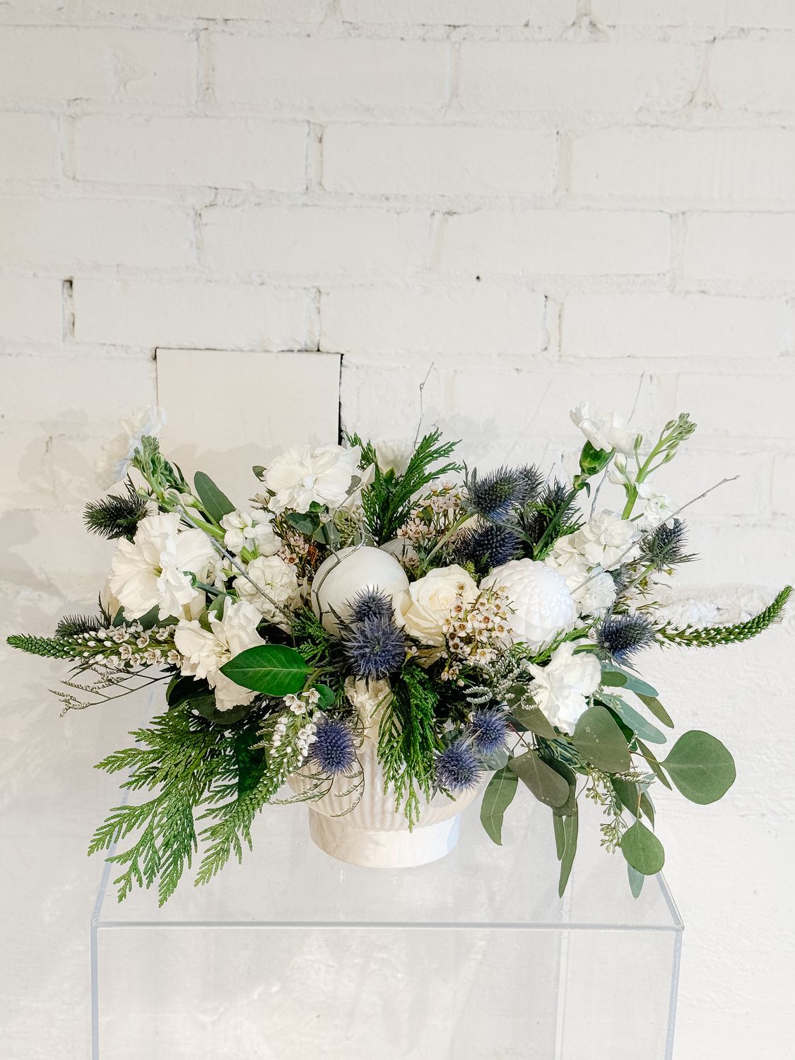 Jingle Prickles winter floral arrangement with blue thistle, white flowers, eucalyptus and evergreen greenery