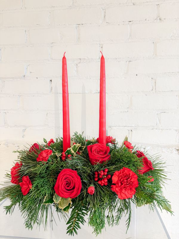 Medium Christmas floral centrepiece with two red candles, red roses and festive greenery