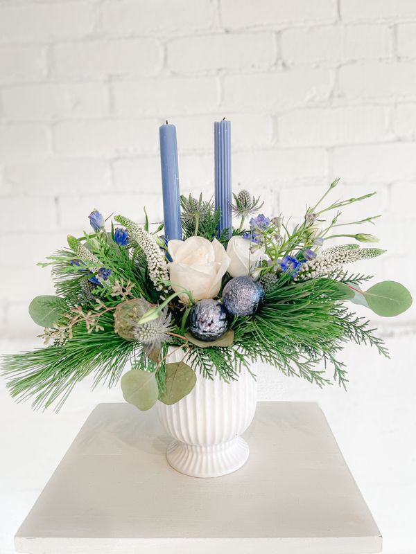 Coastal Candlelight Christmas centrepiece with white roses, blue candles, thistle and evergreen greenery