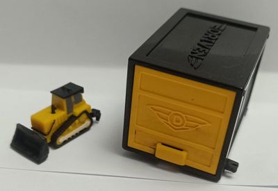 NELA-q, Carro miniatura  Bulldozer miniatura color amarillo y negro, con orugas y una hoja frontal.