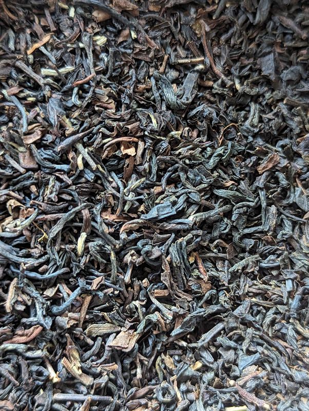 A background of tea, ranging in shade from dark reddish brown to the more standard near black.
