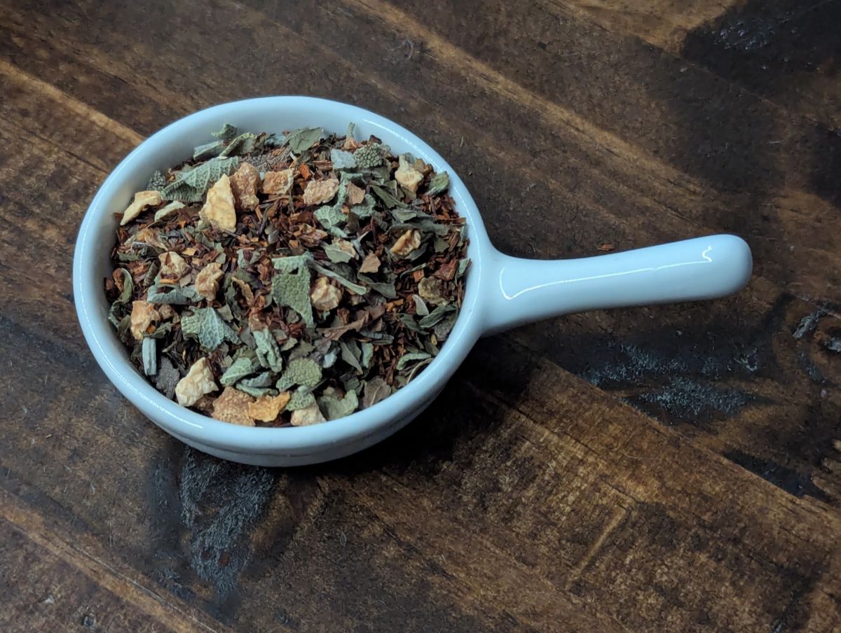 A small handled white bowl full of a blend of Lemon Peel, Rooibos, Sage, and Peppermint.