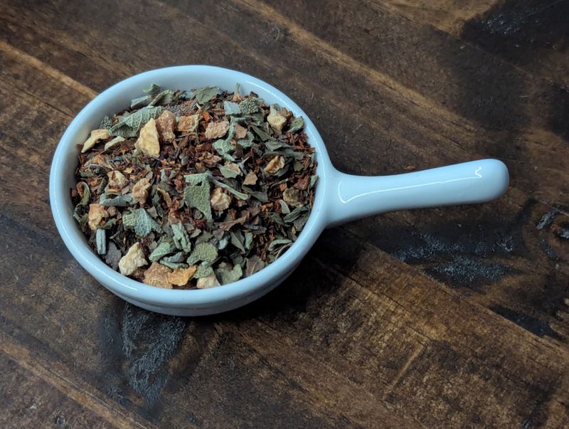 A small handled white bowl full of a blend of Lemon Peel, Rooibos, Sage, and Peppermint.