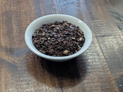 A small white bowl full of a blend of mate, chicory, dandelion root, and cacao shells.