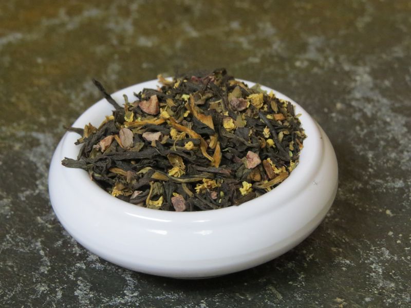 A small white bowl full of a blend of black tea, cacao nibs, elderflower, cinnamon, and tulsi.