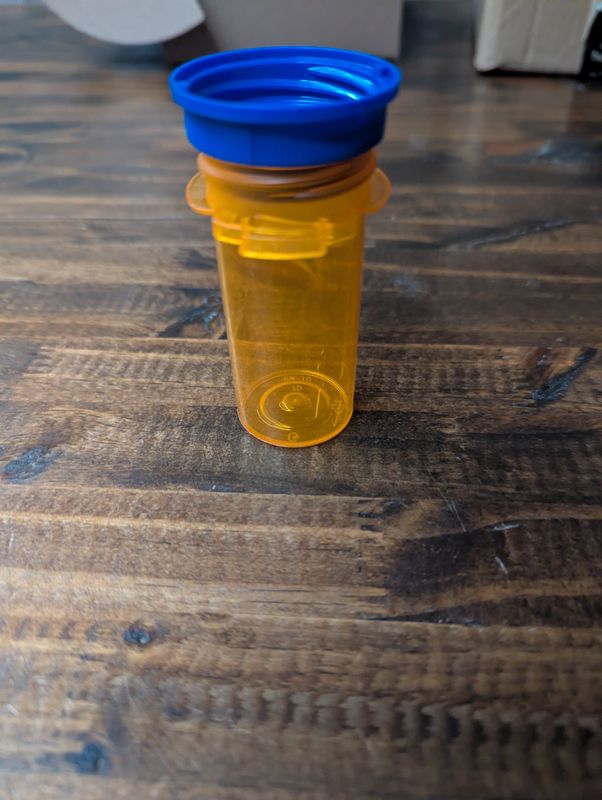 A transluscent orange pill bottle with a blue lid.