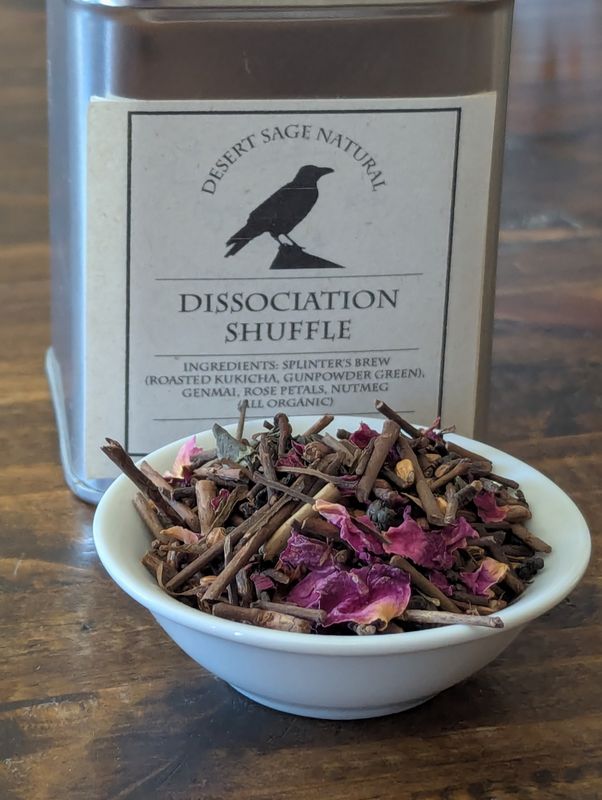 The picture shows a small white bowl full of Dissociation Shuffle sitting in front of a tin with name and ingredients.
