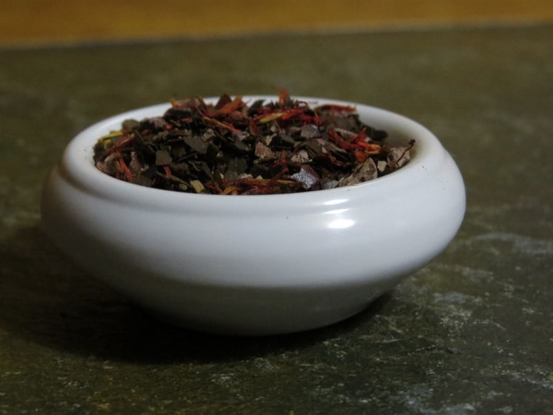 A small bowl full of a blend of Roasted Mate, Cacao Nibs, Red Chile Flakes, and Safflower.