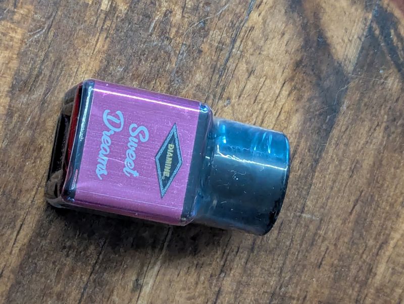 A plastic bottle with a black lid labeled "Diamine Sweet Dreams," still heat sealed.