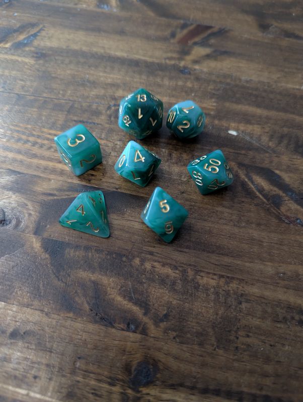 A full set of mossy green dice with gold lettering.