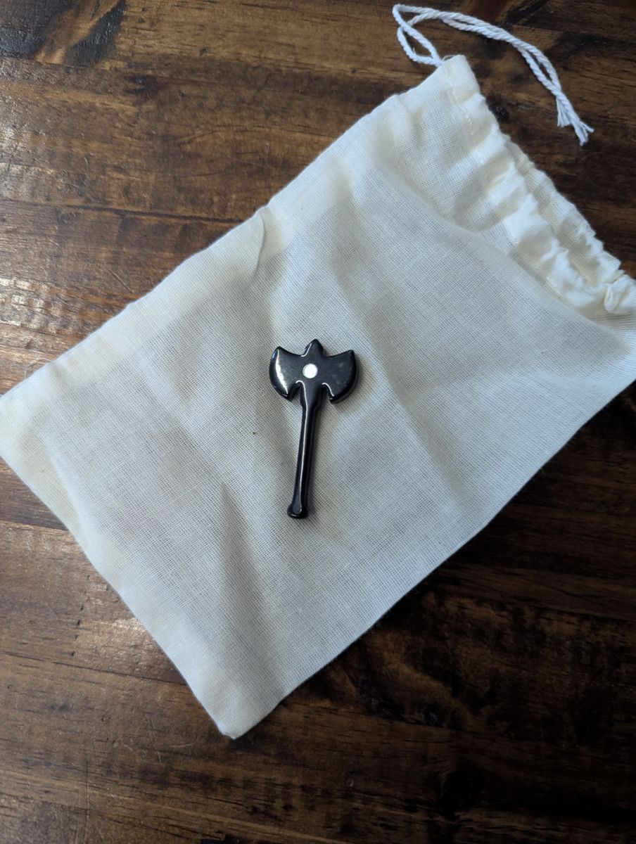 A black d2 with white dots, shaped like a two bladed axe.