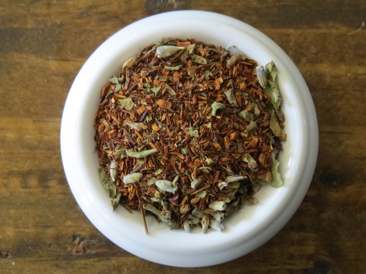 A small white bowl full of a blend of red rooibos, tulsi, and lavender.