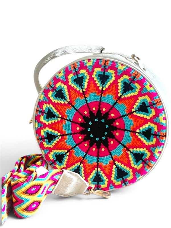 Bolso redondo en genuina piel, con frente en tejido wayuu y cinturón largo tejido.