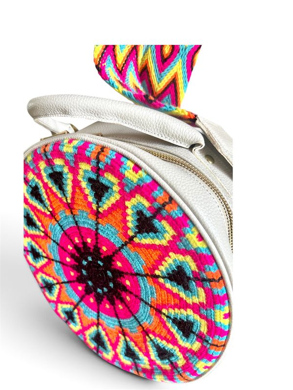 Bolso redondo en genuina piel, con frente en tejido wayuu y cinturón largo tejido.